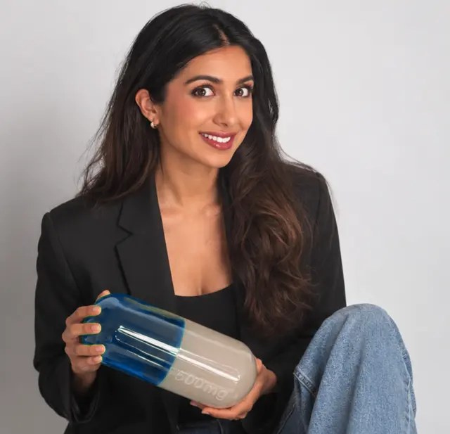 Deeya Kotecha holding a large model capsule