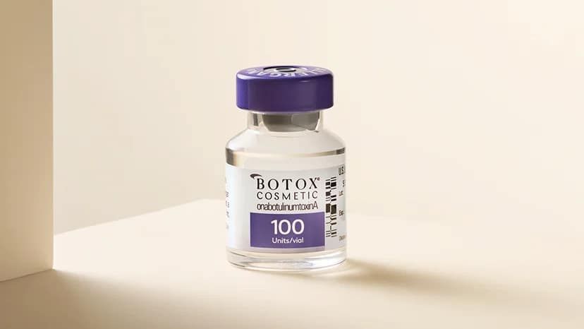 A vial of Botox on a cream background